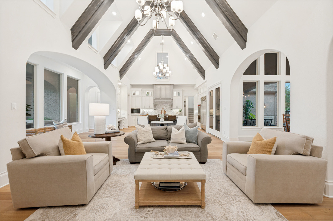 Living room with vaulted beamed ceiling opening to the kitchen